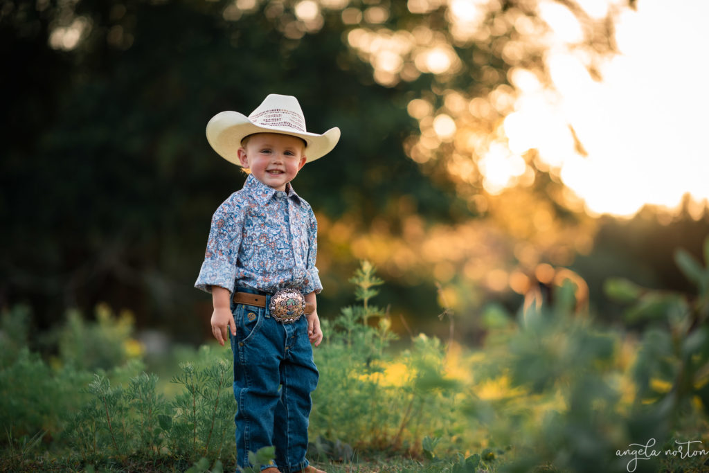 little boy in cowboy hat during golden hour