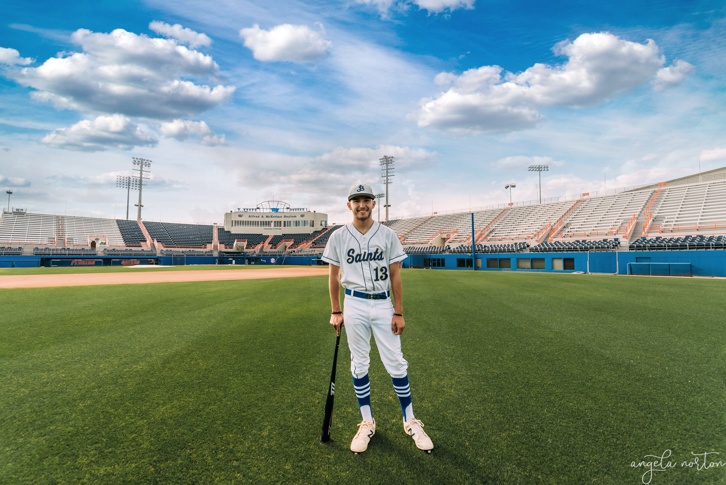 young man standing in the middle of the gators baseball stadium